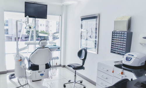 Picture of a dental procedure room representing the dental services of the Costa Rica Dental Centre in San Jose, Costa Rica.  The interior is very modern and has primarily white colors.